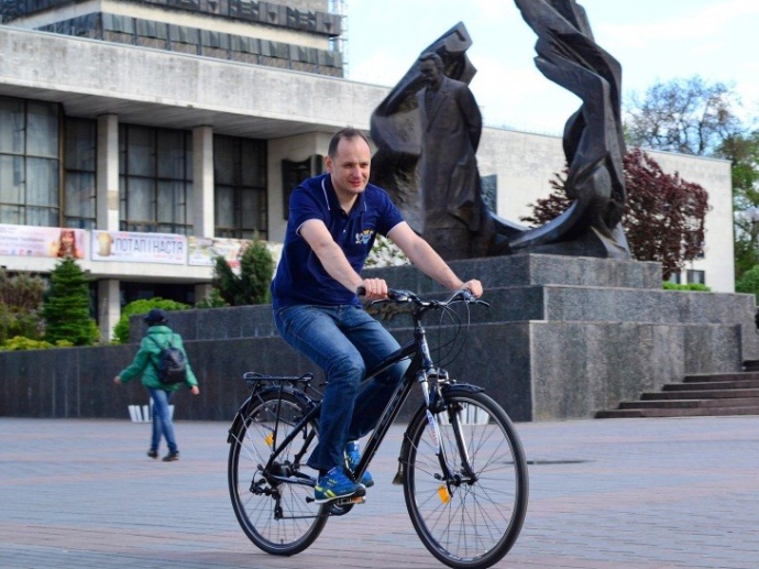 его   фото в темно-синий поло с велосипедом   , Которым он призывает местных жителей прийти на велопробег, можно увидеть во всех уголках Ивано-Франковска